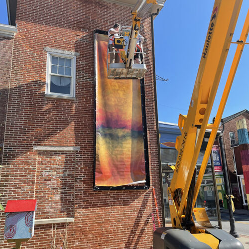 Crane installing outdoor painting